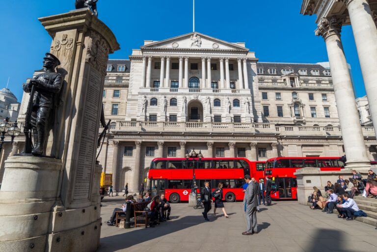 The Bank of England in the City of London as commuters walk past.